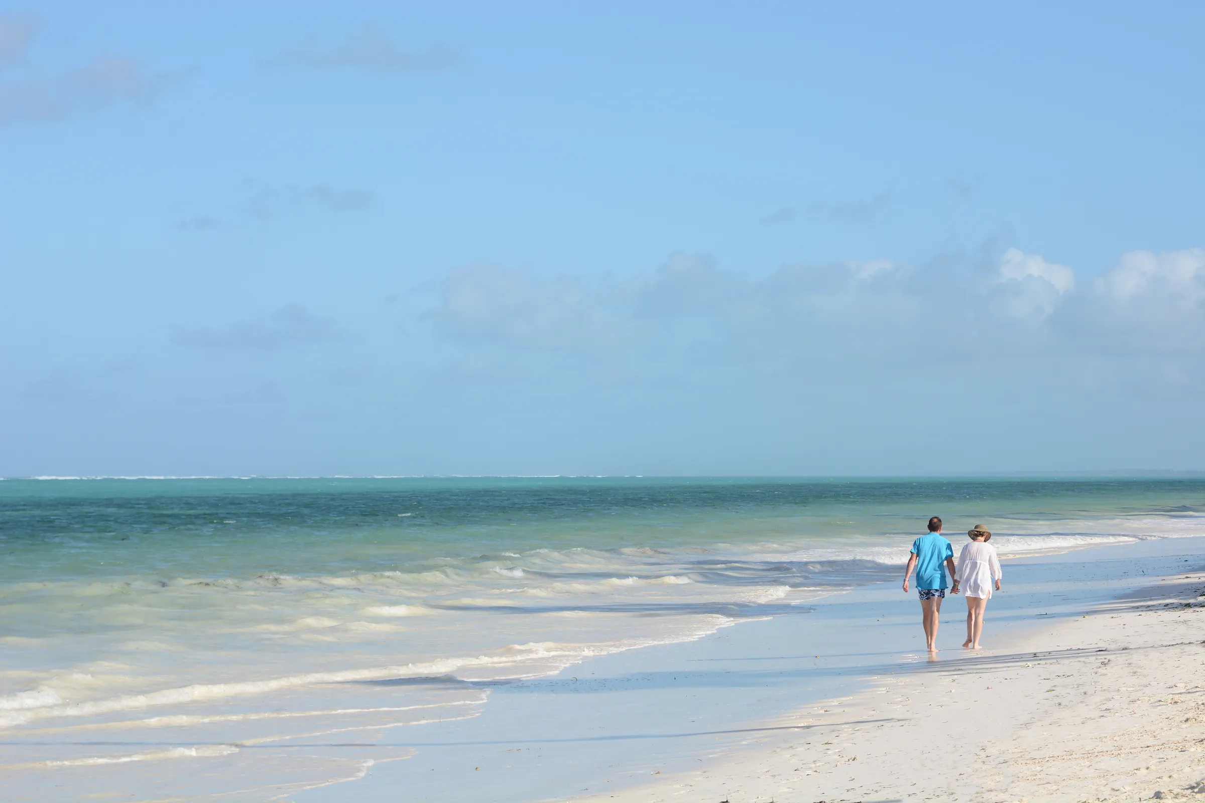 Par promenerar längs stranden i Bwejuu på Zanzibars östkust