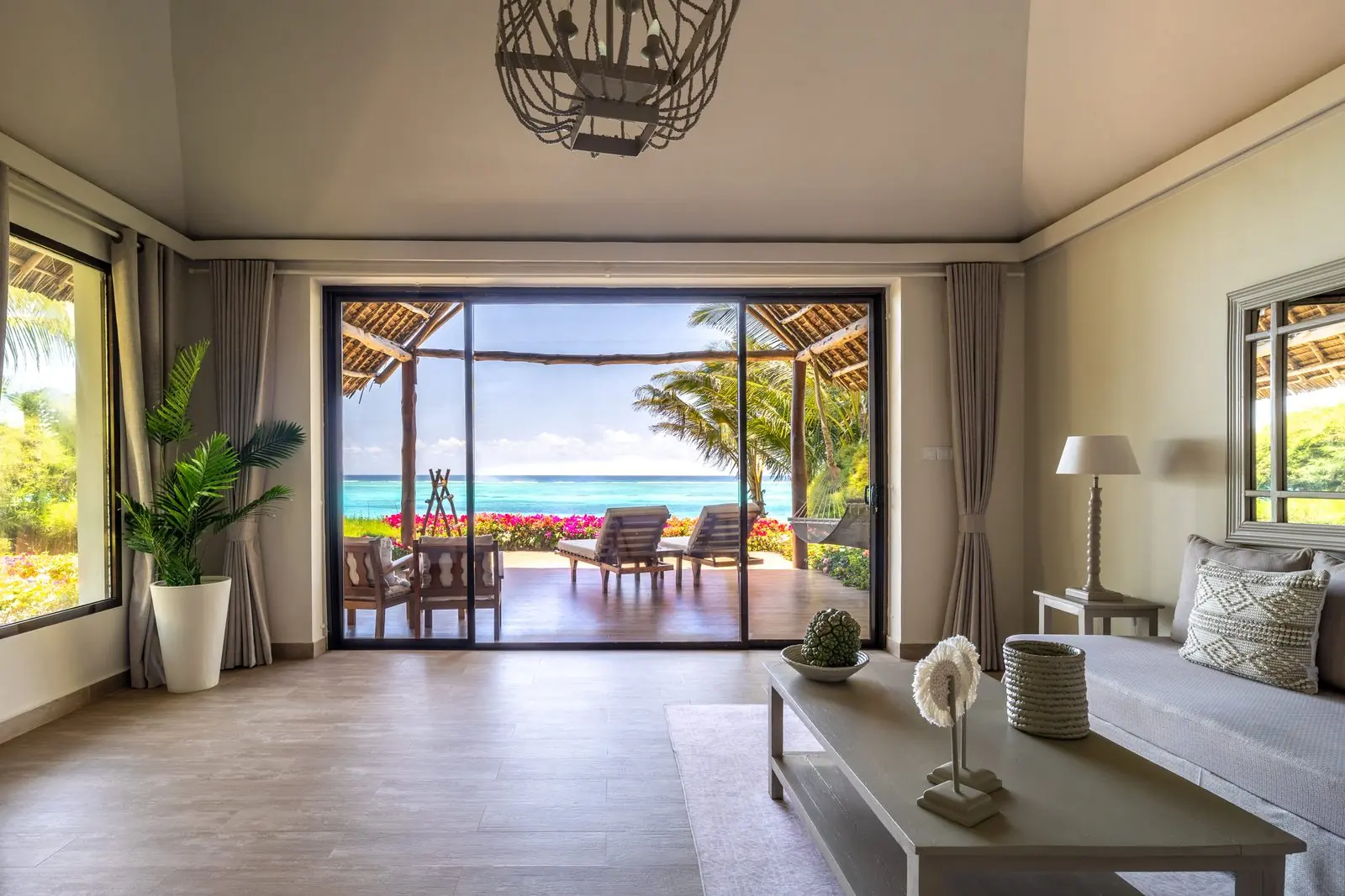 Villa på Zawadi med utsikt genom glasdörrarna mot terrassen och havet