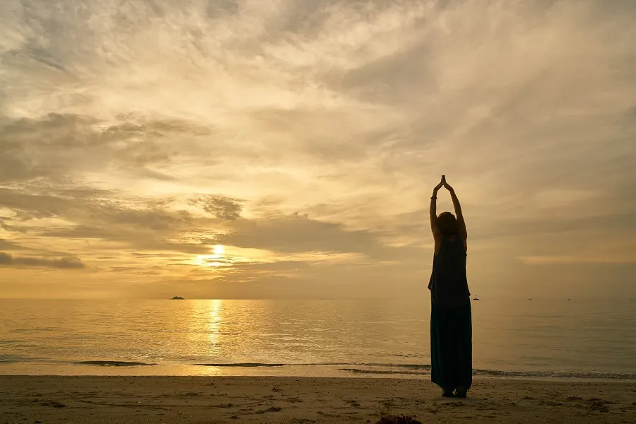 Yoga på stranden i solnedgången på Zanzibar